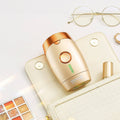 Vevor IPL hair removal device styled on a beige clutch with eyeglasses and makeup palette, emphasizing luxurious, at-home beauty treatment