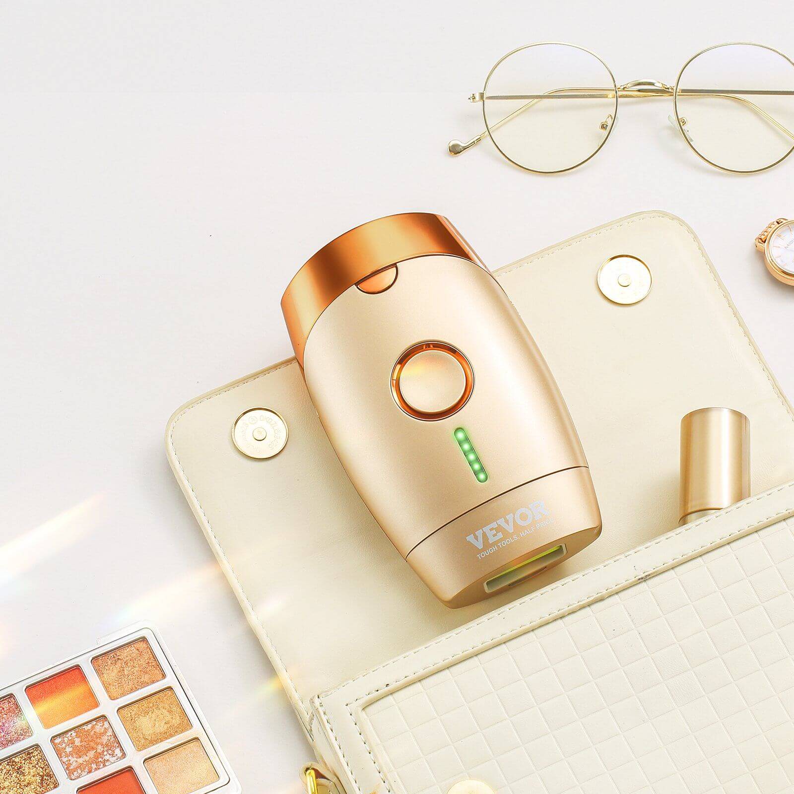 Vevor IPL hair removal device styled on a beige clutch with eyeglasses and makeup palette, emphasizing luxurious, at-home beauty treatment
